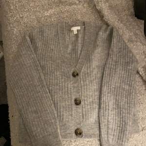 Grå stickad tröja med knappar. Från Vero Moda, nyköpt-250 . Köpte idag men ville inte ha den. Använd 1 gång.