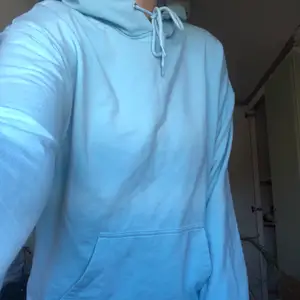 En ljusblå hoodie, knappt använd. Storlek M men passar bra som S också