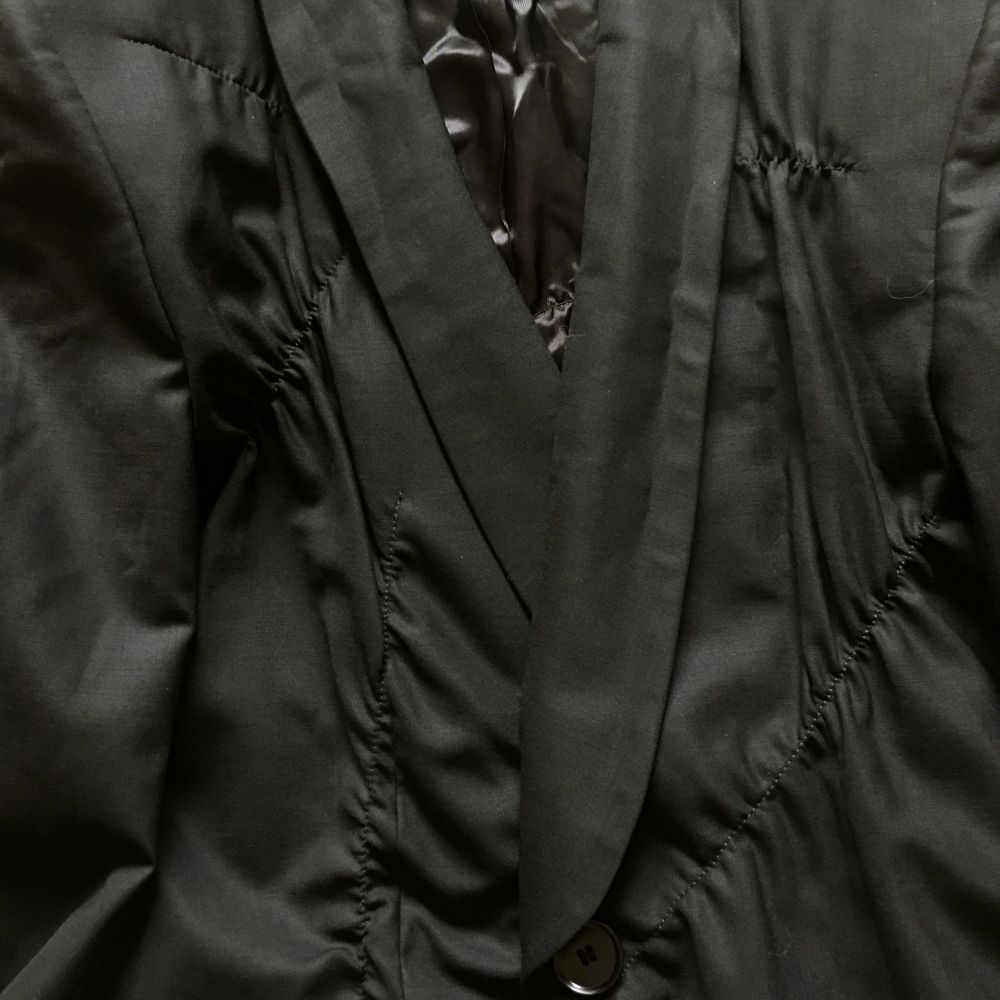 En assymetriskt veckad svart kavaj i tunn ull från Cos, så kallad sommarull som fungerar bra och andas när det är varnt. Storlek 38, oversize modell med fint fall i tyget. Jag har fler bilder på passformen som jag kan skicka! Superfina detaljer och jättefin kvalitet, den här förtjänar att bäras!. Jackor.