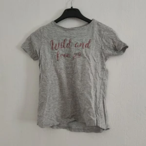T-shirt med text - Bra skick och en fin detalj på ryggen. Lite längre över rumpan än på framsidan. Köparen står för frakten. 