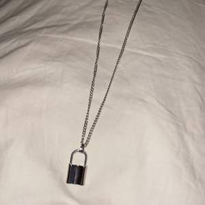 Halsband med ”lås” hänge, ca 52cm på längsta snäppet. Aldrig använt. 
