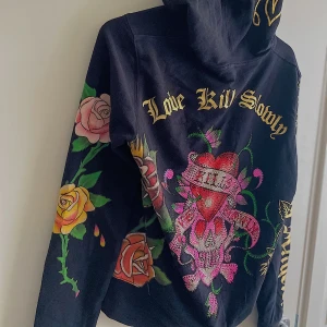 y2k Ed hardy zip-up hoodie - Säljer en ed hardy zip-up hoodie som e knappt använd, alla rhinestones finns kvar på tröjan :) bud i kommenterna eller skriv till mig privat :)💕 tar direktköp pris oxå 😇 Höja budet med minst 20kr !BUD LIGGER PÅ:650kr!!! BUDGIVNINGEN STÄNGER SNART! bud ELLER SKRIV TILL mig för direkt/köp! 