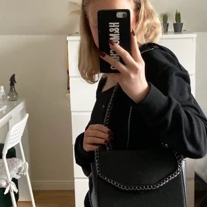 Svart kedjeväska  - En svart kedjeväska med lång kedja och fickor inuti ( nypris 300kr ) använd några enstaka gånger💓 har fått den så har inte så jättebra koll:(