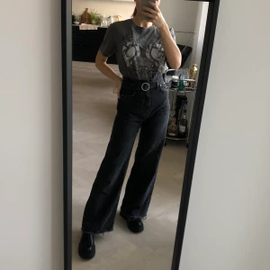 Washed svarta jeans - ”Tvättade” svarta jeans med tillhörande skärp. Högmidjade och vida där nere. 