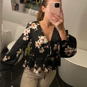 Svart blus med blommor - Svart blus med rosa blommor på. Snålt använd och i nyskick. Stl XS