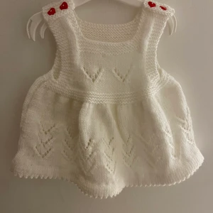 Barnkläder  - Stickad klänning med skor till. Passar fram till 6 månader gammal bebis. Är i nyskick, aldrig använd. Handmade