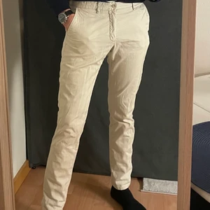 Massimo Dutti byxor - Byxor i ljus beige färg, typ off-white. Är i storlek EUR 40, US 31. Byxorna har verticala ränder som mönster i tyget (se bild 3)