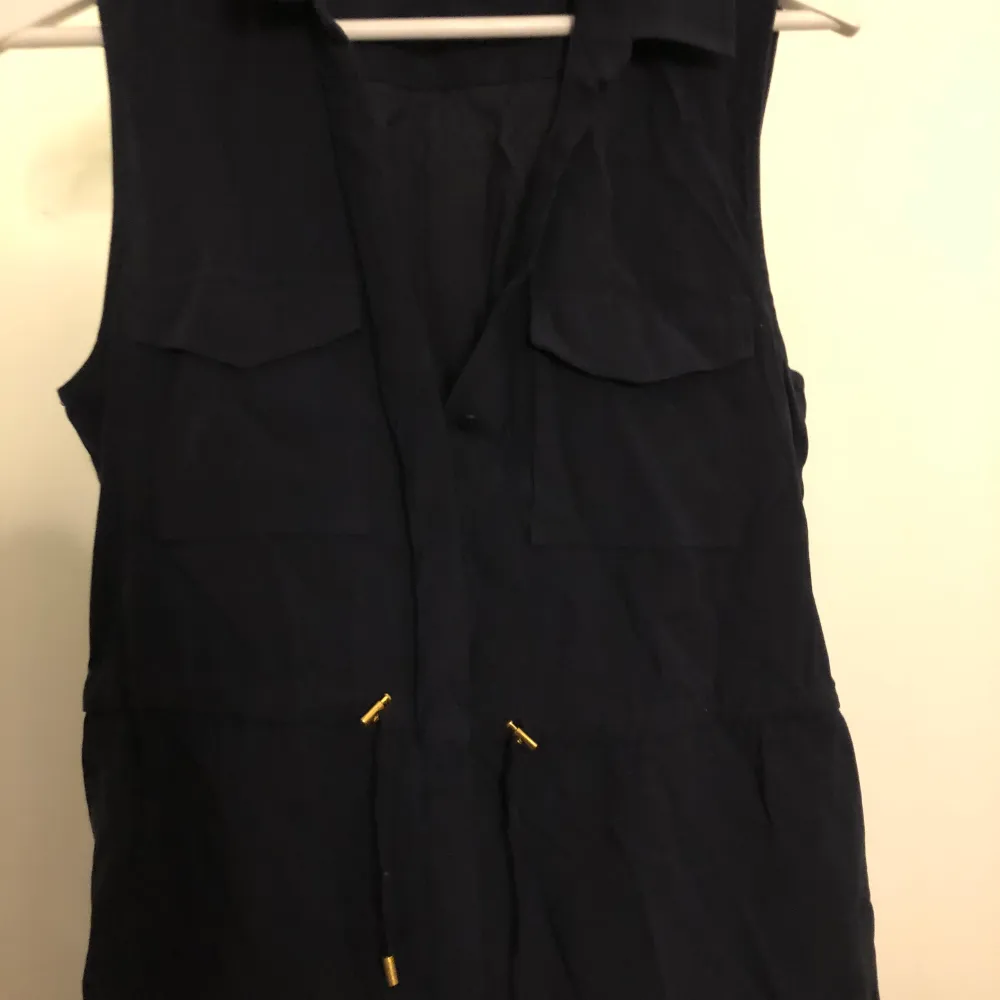 En svart/blå klänning från hm som går att spänna åt i midjan i stl 38. Klänningar.