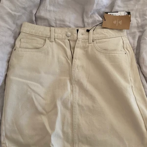 jeanskjol - Beige jeanskjol ifrån Vero Moda i storlek M. Helt oanvänd med prislappen kvar. Nypris 299kr, har aldrig kommit till användning. Köparen står för frakten.