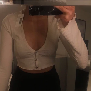 Beige topp - Helt oanvänd beige topp med knappar och volangärmar från Nelly i storlek XS! Säljes pga att den inte kommit till användning💕