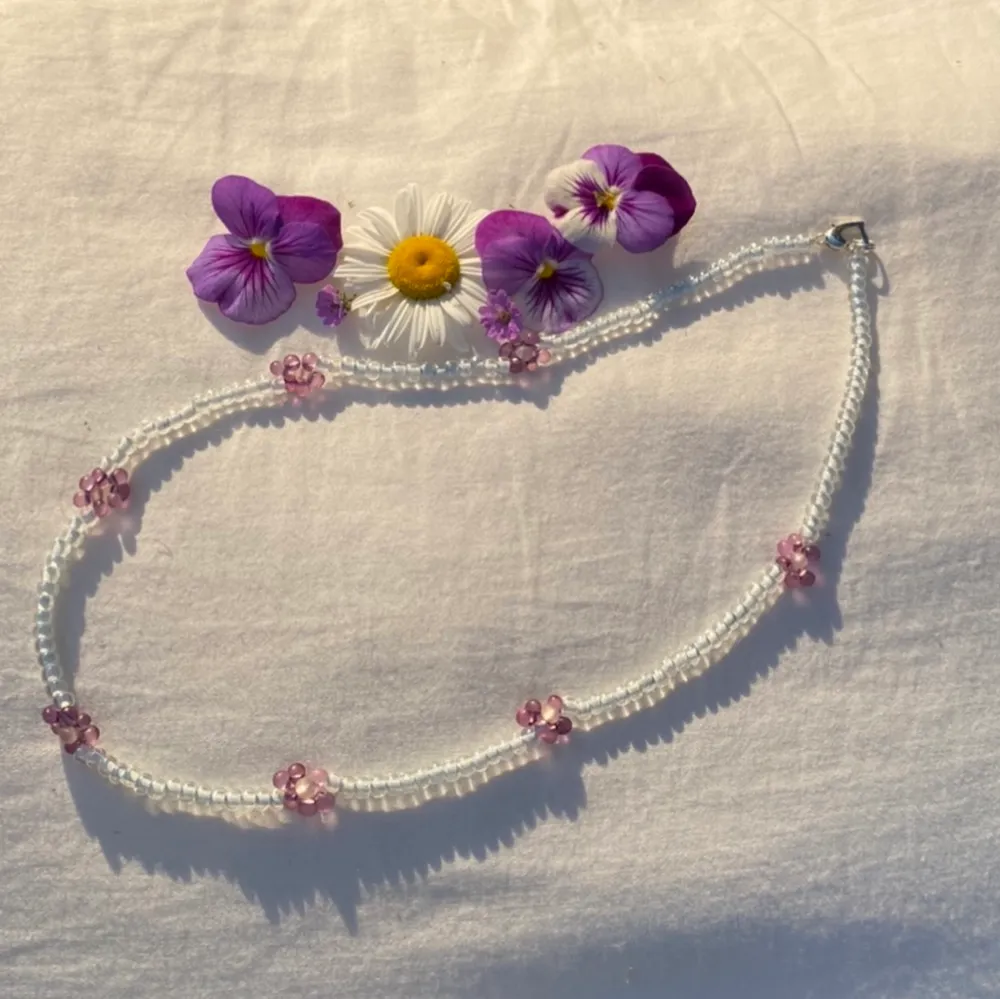 Supergulligt halsband med blommor på, gjort av glaspärlor. Kunden står för frakten🌼. Accessoarer.