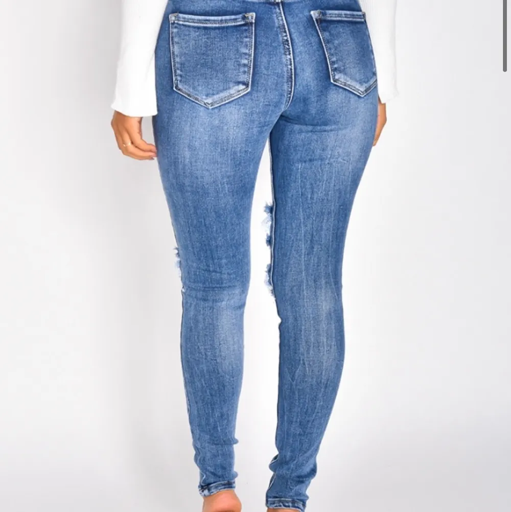 Snygga jeans med hål i storlek S, mörkblå färg som är snygga och är mellanmidjade. Helt OANVÄNDA. Bra material och sitter väldigt snyggt på. Passar alla längder och former!. Jeans & Byxor.