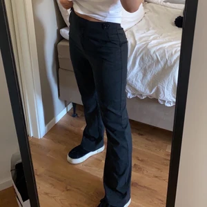 Svarta Kostymbyxor  - Säljer dessa snygga kostymbyxor med hög midja från Misslisibell x NA-KD i Storlek 38. Byxorna är använda ett par gånger men är i bra skick. Snygg detalj med knapp på båda sidor vid midjan.