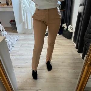 Kostymbyxor med slits - Jätte fina beiga kostymbyxor med slits, säljer för dom är lite för korta för min smak, jag är 170 lång. Endast testade. Storlek S