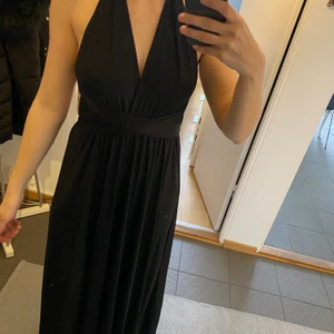 Klänning - Svart klänning i superskönt material som går att knyta hur man vill, oanvänd 