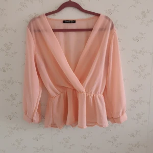 Blus BOOHOO - En super söt ljusrosa blus från Boohoo. Den är ganska genomskinlig och blir jättefint med ett linne under. En väldigt skön tröja att ha på sommaren. Storlek 38. 