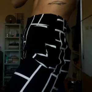 Svartvita kostymbyxor - Supercoola kostymbyxor, högmidjade och med slits på ena benet. Raka/vida i modellen. Säljes pga tyvärr för korta för mig, är 175 lång. Kan skicka/mötas upp