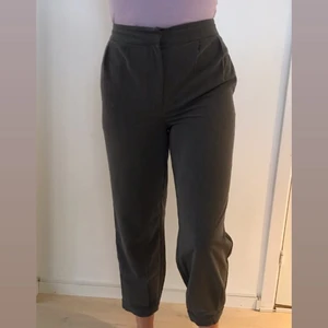 Breda kostymbyxor från NA-KD 💜 - Mörkgråa kostymbyxor från NA-KD. Bara använt ett fåtal gånger. Säljes på grund av att de inte längre passar. En knapp har fallit av (se bild 3) men man kan lätt sy på en ny. Obs. fraktkostnaden kan vara fel 💜