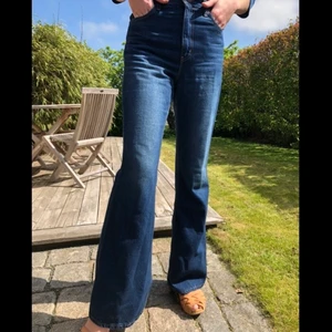 Levi’s 70’s high flare jeans strl. 26/32 - Helt nya 70’s high flare jeans från Levi’s i färgen medium indigo. Hög midja och utsvängda ben i sann 70-talsstil. Jeansen sitter snyggt och kroppsnära kring midja, stuss och lår med vida ben som svänger ut. Oanvända. Jag som har på mig dem i bilden är 172cm lång och väger 60kg. Sitter då en aning löst. 