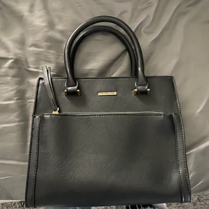 Svart snygg handväska - Svart snygg handväska som även går att göra till en axelväska med remmen på andra bilden. säljer pågrund av att den aldrig är använd och kommer nog inte använda den heller så den är i nyskick! perfekt nu till sommaren. frakt ingår i priset!! tveka inte vid frågor🥰 priset kan diskuteras!