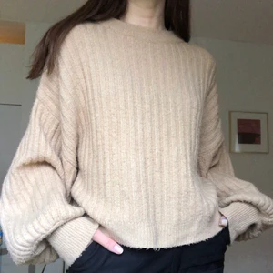 Stickad tröja - Beige/brun kabelstickad tröja från Gina Tricot med ballongärmar. Väldigt bra skick, sparsamt använd. Storlek M men sitter snyggt och oversized på mig. Passar mellan XS-M