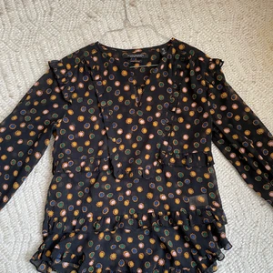 Scotch & soda blus - Super fin svart blus med ett coolt prickigt mönster, volang detaljer och knapp! Använd ett fåtal gånger. Nypris 1200kr 