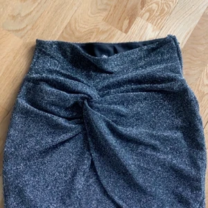 Glittrig kjol  - Grå glittrig kjol perfekt till fest eller nyår! Fin detalj i mitten på kjolen och tajt/figursydd passform💕 storlek S 