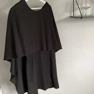 Svart klänning från H&M - Svart klänning med djup rygg. Klänningen är figursydd med stora ärmar.