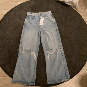 Oanvända jeans från Gina tricot  - Håliga blå jeans från Gina. Sitter ass bra i längd men sitter ej bra i midjan då de är för små.