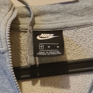 Nike Huvtröja - En luvtröja med dragkedja av märket Nike. Liten reva i höger ärm annars fint skick. 