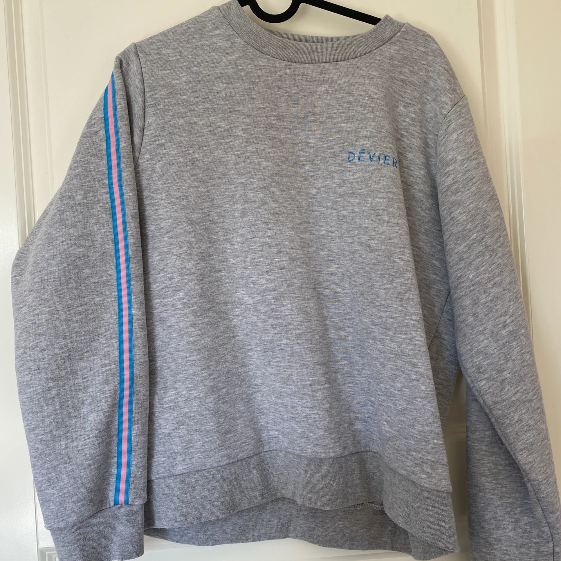 Grå sweatshirt med blåa och rosa detaljer