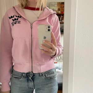 Rosa tröja sweden - Ljusrosa zip up hoodie med texten SWE och tre kronor, står också sweden upp och ned på luvan. Köpte second hand, den är använd och lite nopprig men väldigt skön. Kan mötas i Stockholm annars betalar köpare frakt. 