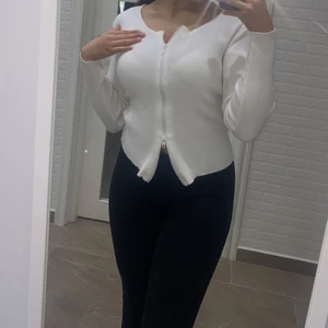 Vit tröja med dubbla dragkedjor  - Tröjan är helt oanvänd (endast testad) då jag köpte fel storlek. Jag bär på S och råkade beställa M. Men det skulle även passa någon med storlek S beroende på hur tight man vill ha. Jag föredrar tightare och därför säljer jag den vidare🌸 frakt tillkommer med 24-48kr 