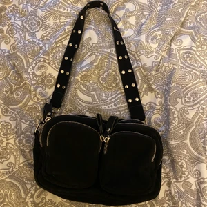 Svart axelväska - Säljer denna superfina väska pga att den inte kommer till användning. Man får med ett svart band i väskan som man kan byta ut mot det prickiga bandet🥰 skriv privat för fler bilder! 