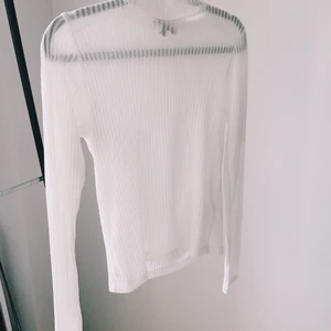 Vit topp - Vit topp från topshop, ribbat och väldigt tunt tyg. Supersnygg under hängselbyxor/klänning. Fint att huden lyser igenom! 