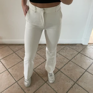 Kostymbyxor  - Vita populära kostymbyxor från Bikbok. Två fickor där fram. Två ”låtsas” fickor där bak. Storlek 34. Nyskick. Säljs för 100kr.