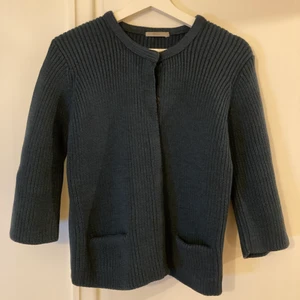 Finstickad kofta ull från COS - Mörkt turkos kofta från COS i 100% ull. Är väldigt varm och skön, kliar inte. Har lite kortare ärm och två mindre fickor på framsidan. Tryckknappar för att stänga. Jag som normalt har S/M har också kunnat ha denna kofta.