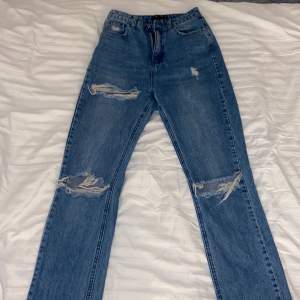 Blåa, raka, högmidjade jeans med slitningsdetaljer💓 Köpta från missguided. Använda Max 2-3 gånger så inprincip oanvända!