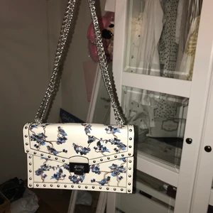 Axelbandsväska med kedja - Otroligt fin axelbandsväska med broderier på🧚🏼🧚🏼 Kedjan går att ha dubbel (första bilden) så man kan variera hur man vill bära den! Silvrigt och ”lyxigt” knäppe <3 Liten innerficka, och i princip oanvänd! 