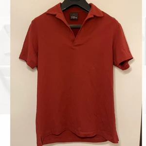 Tegelröd Piké från Oscar Jacobson - Cool tegelröd piké från Oscar Jacobson med knapplös bowlingkrage. Aktuell modell nypris 900kr. Sparsamt använd, tycker den är skitsnygg, säljer den endast då den är för liten för mig. Frakt tillkommer