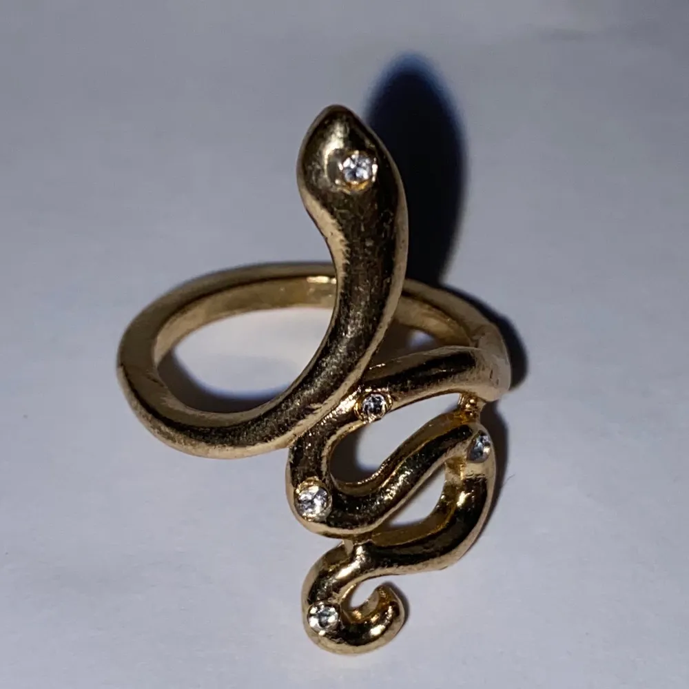 Silverring i form av en orm med kristaller och gulddetaljer.. Accessoarer.