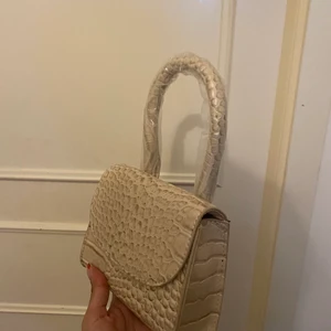 Väska från Nelly  - En mini bag från Nelly i färgen beige helt oanvänd 