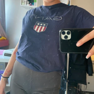 Gant t-shirt - Marinblå T-shirt från Gant köpt på kidsbrandstore.se. Storlek 158-164cm, men passar lika bra på en med storlek S. Inköpt för ca 2 år sedan, och har använt den under 1 sommar. Överlag fint skick trots att den är använd. 