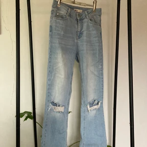 Bootcut Jeans med slitna knän - Jättefina ljusblå bootcut jeans med slitningar på knäna! Köpta från GinaTricot. Köparen står för frakt! Hör gärna av dig om du har frågor🤍
