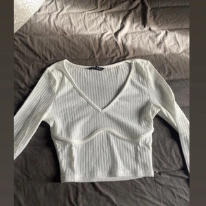 Vit croppad top - Jättefin top med detalj under brösten, storlek S men passar xs också. Endast testad lite kort för min smak🤍 Frakten är inräknad i priset!