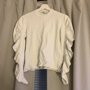 Vit tröja - Vit tröja med volanger på armarna och tjockt matrial 