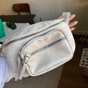 Midjeväska  - Beige/ljusrosa väska som är rymlig. 