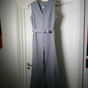 70s byxdress - Coolaste plagget! Äkta 70-talsbyxdress i grått material som känns som en ullblandning. Ordentligt vida ben och bälte i midjan. Toppenskick! Passar en S perfekt🍀