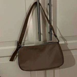 Brun axelväska  - En helt ny väska som endast har har använts två gånger. Bra förvaring för det nödvändigaste. Köparen står för frakt. 