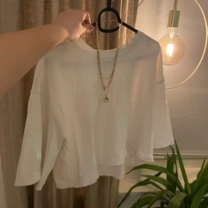 Vit T-shirt - En vit T-shirt som är till armvecken och kort vid magen, den har inte använts sen jag köpte den men den är mycket välbevarad och en ljusare nyans av vitt. Den är kort oversize och ganska bred